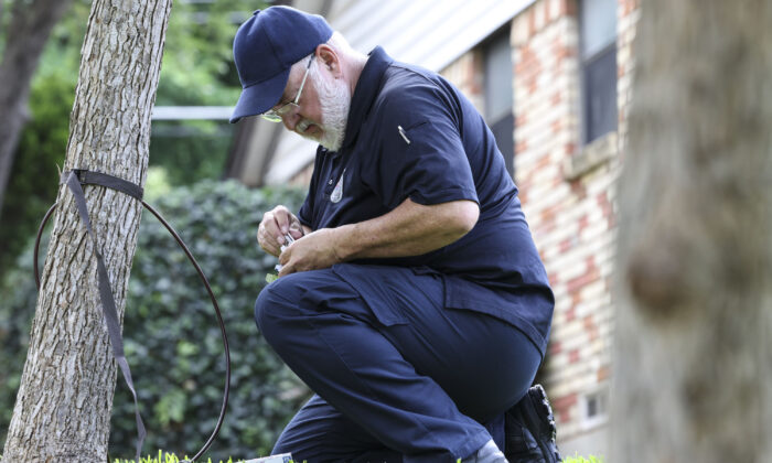 A City of Dallas Animal Service Officer removes a camera from a tree two doors down from where on May 3, 2022 a 2-year-old was attacked by a coyote in Dallas, on May 4, 2022. (Rebecca Slezak/The Dallas Morning News/TNS)