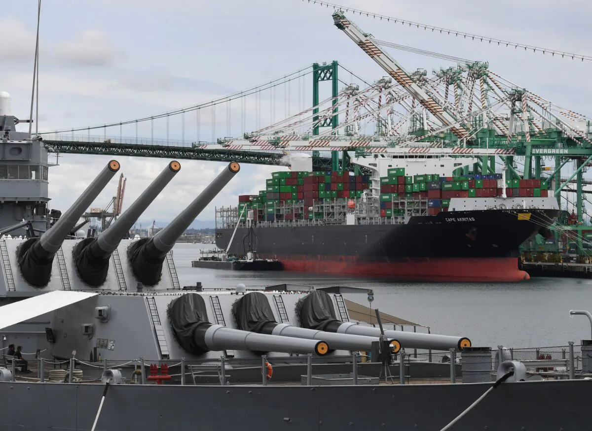 A container ship unloads its cargo beside the battleship USS Iowa at the main port terminal in Long Beach, Calif., on May 10, 2019. (Mark Ralston/ AFP via Getty Images)