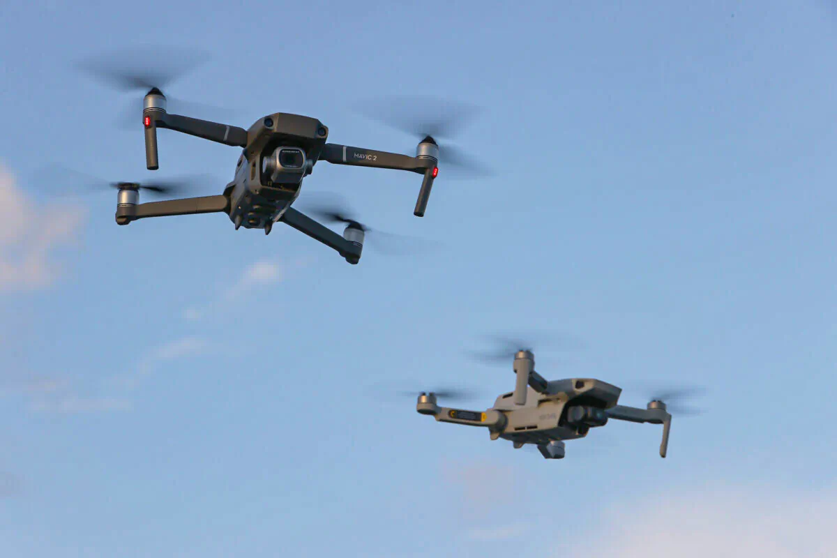 A DJI Mavic 2 Pro and DJi Mavic Mini made by the Chinese drone maker fly near each other in Miami, Florida, on Dec. 15, 2021. (Joe Raedle/Getty Images)