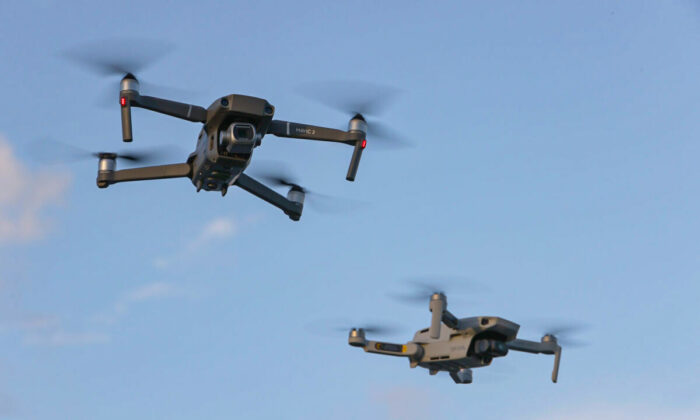 A DJI Mavic 2 Pro and DJi Mavic Mini made by the Chinese drone maker fly near each other in Miami, Florida, on Dec. 15, 2021. (Joe Raedle/Getty Images)