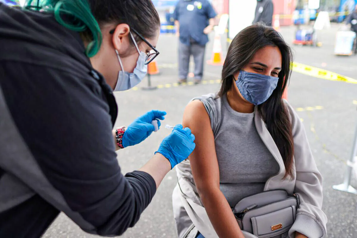 A woman receives a COVID-19 vaccine in Los Angeles, Calif., on March 25, 2021. (Lucy Nicholson/Reuters)