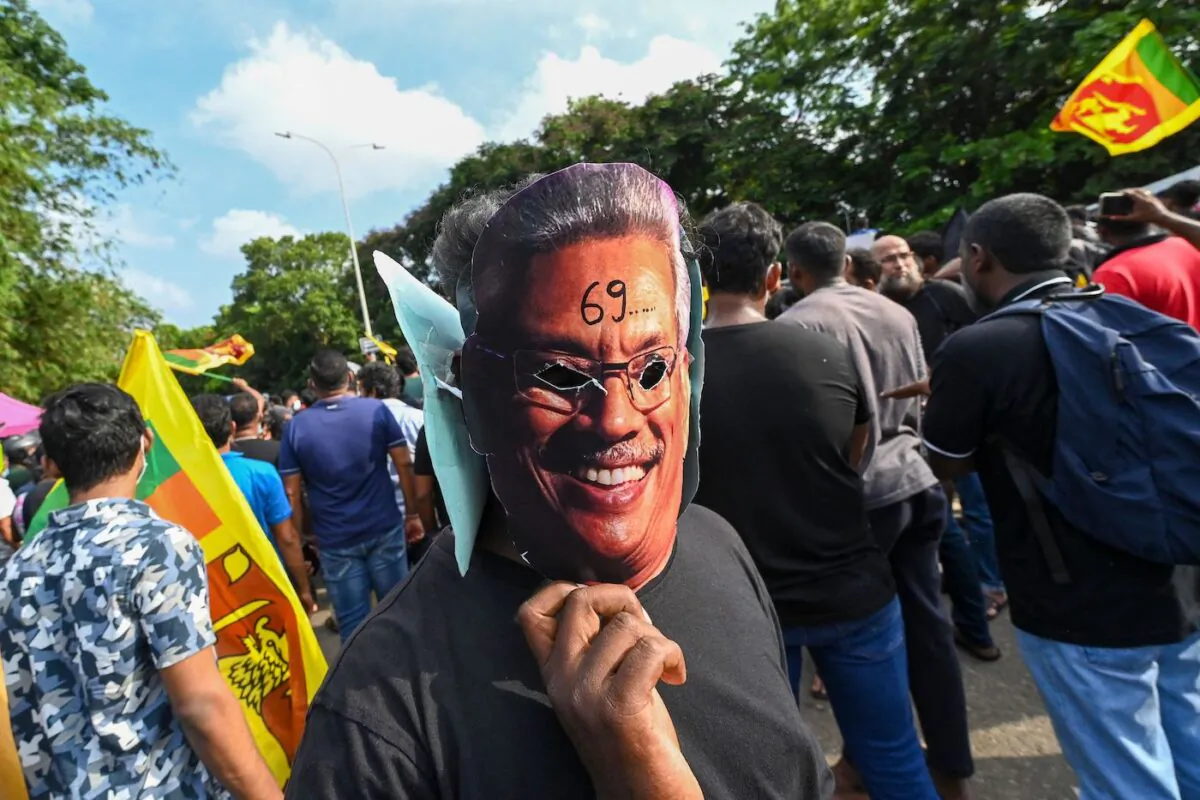 A demonstrator wearing a mask of Sri Lanka's President Gotabaya Rajapaksa takes part in a demonstration over the country's crippling economic crisis, near the parliament building in Colombo on May 6, 2022. (Ishara S. Kodikara/AFP via Getty Images)