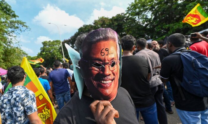 Demonstrant w masce prezydenta Sri Lanki Gotabaya Rajapaksa bierze udział w demonstracji w związku z paraliżującym kryzysem gospodarczym w kraju, w pobliżu budynku parlamentu w Kolombo 6 maja 2022 r. (Ishara S. Kodikara/AFP via Getty Images)