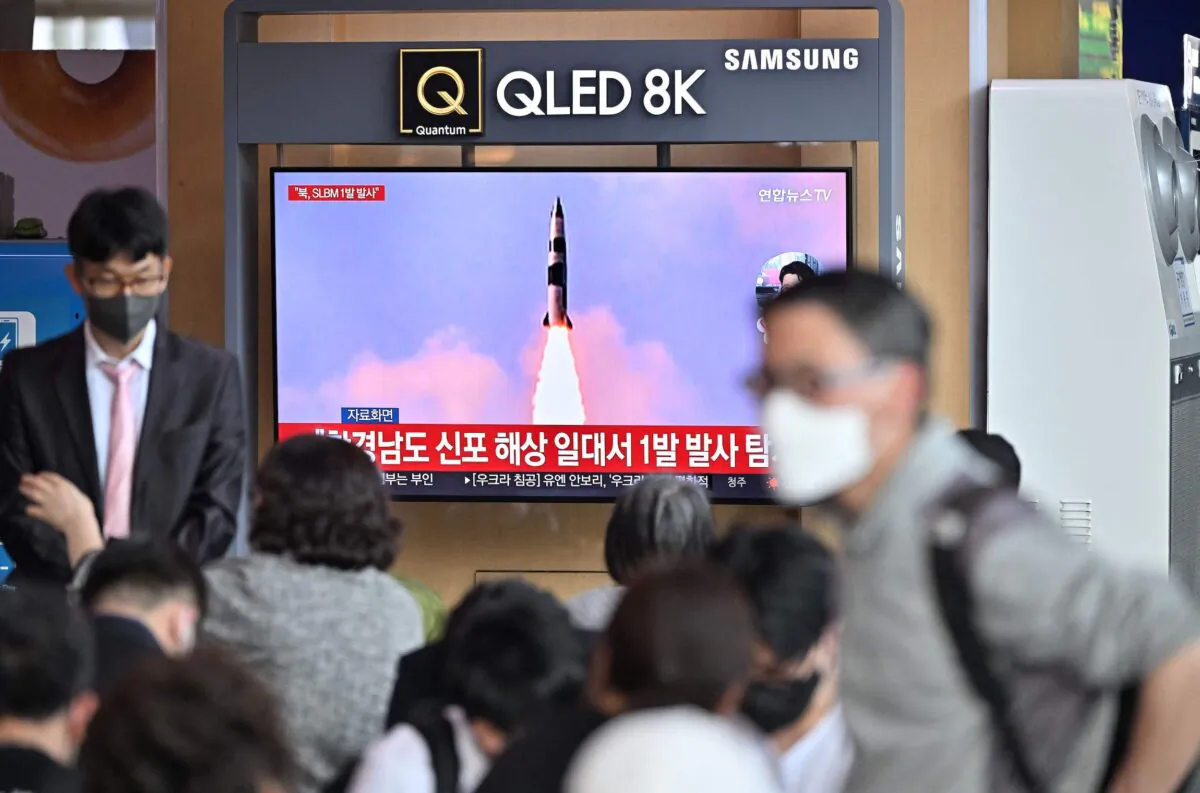 People watch a television screen showing a news broadcast with file footage of a North Korean missile test, at a railway station in Seoul on May 7, 2022, after North Korea fired a submarine-launched ballistic missile according to South Korea's military. (Jung Yeon-je/AFP via Getty Images)