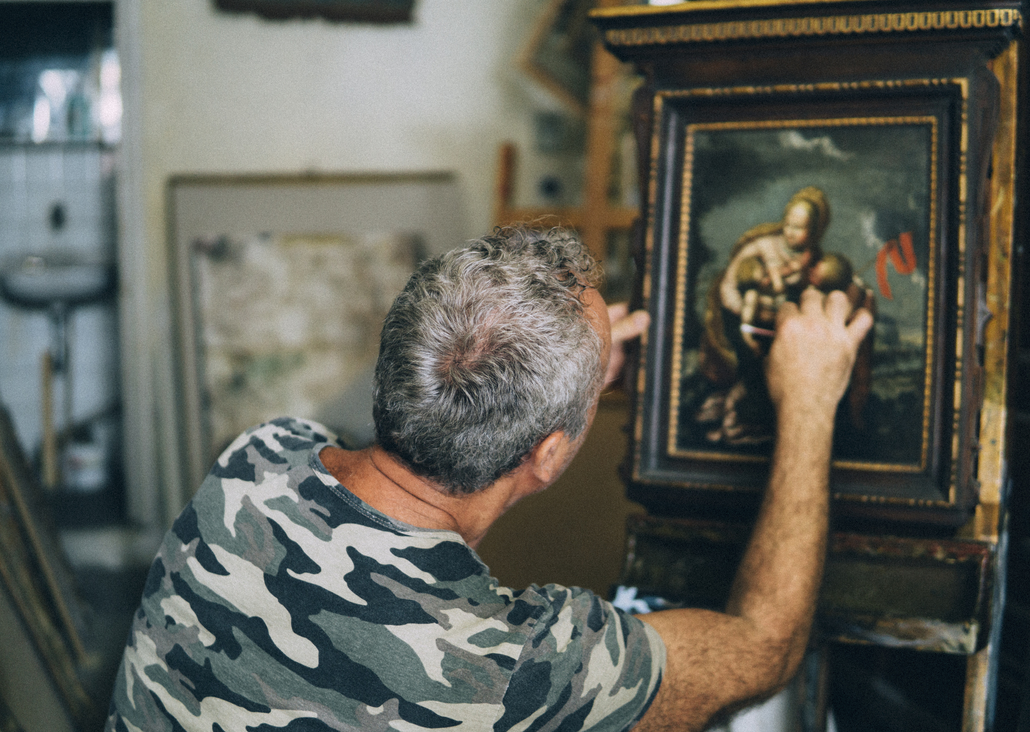 Artist restoring an old painting