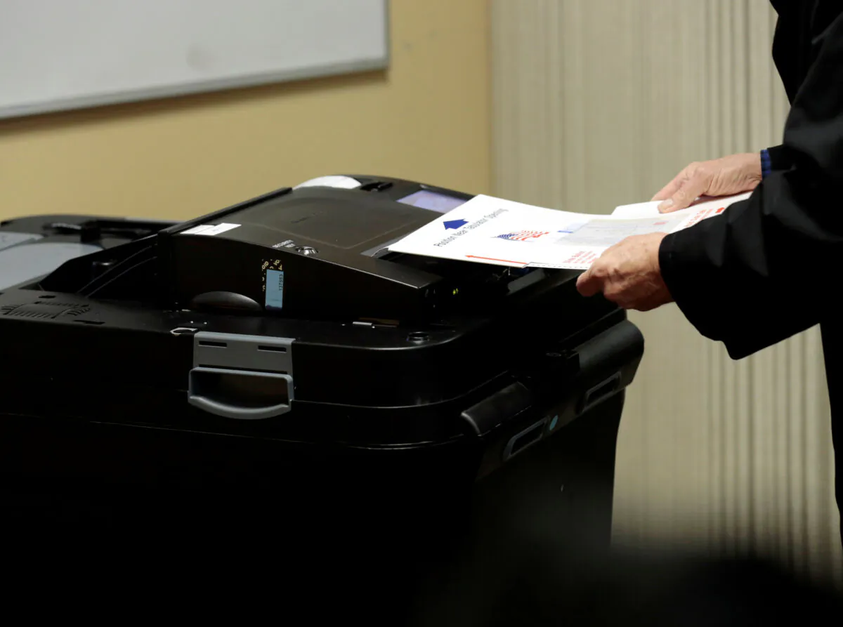 A person places his ballot in a tabulating machine in East Lansing, Mich., in a file photograph. (Jeff Kowalsky/Reuters)
