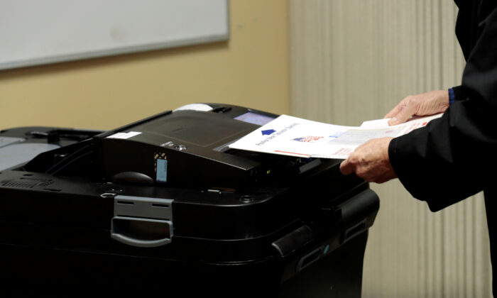 A person places his ballot in a tabulating machine in East Lansing, Mich., in a file photograph. (Jeff Kowalsky/Reuters)