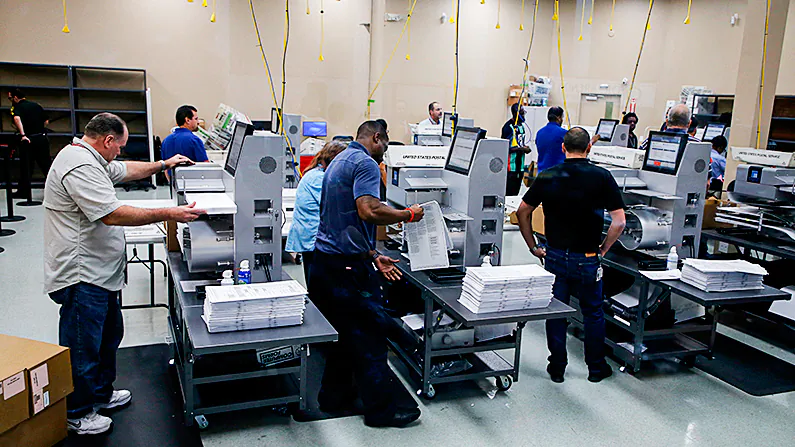 Elections staff load ballots into machines as recounting begins at the Broward County Supervisor of Elections Office in Lauderhill, Fla., on Nov. 11, 2018. (Joe Skipper/Getty Images)