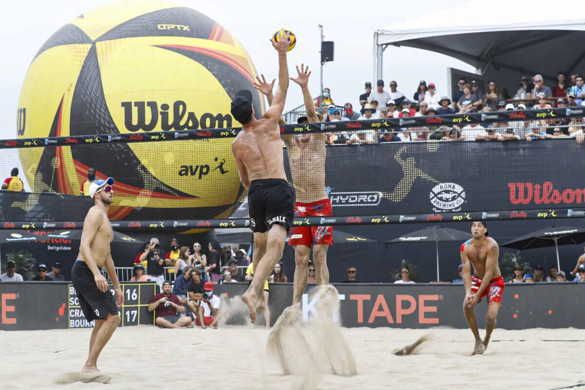 Tri Bourne and Chaim Schalk jump for the ball at the net in the semi final match at the AVP Gold Series Manhattan Beach Open, in Manhattan Beach, Calif., on August 22, 2021 (Joe Scarnici/Getty Images)