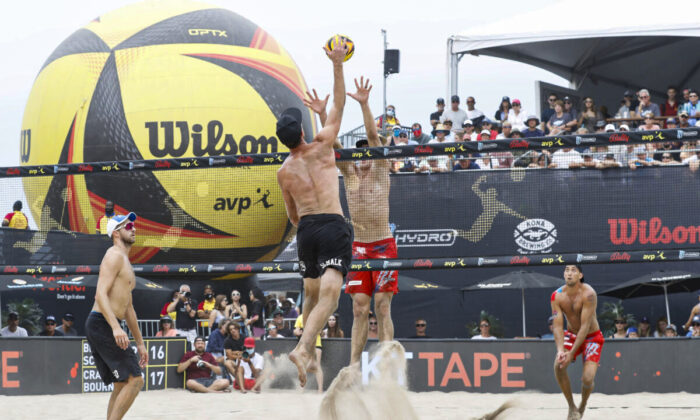 Tri Bourne and Chaim Schalk jump for the ball at the net in the semi final match at the AVP Gold Series Manhattan Beach Open, in Manhattan Beach, Calif., on August 22, 2021  (Joe Scarnici/Getty Images)