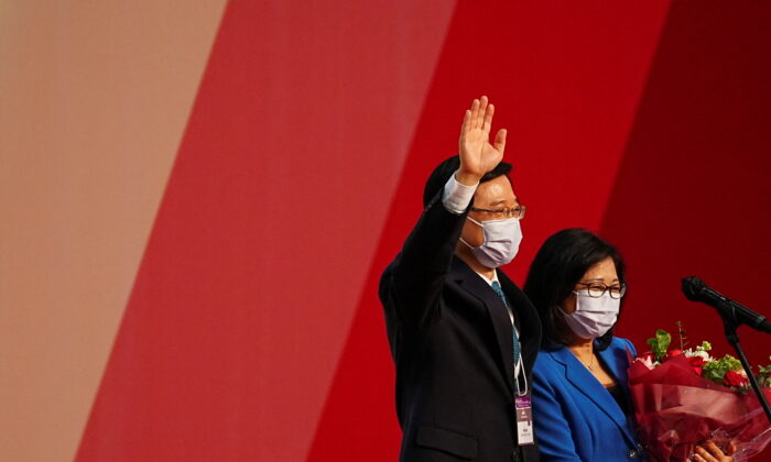 John Lee waves next to his wife Janet Lam Lai-sim after being elected as Hong Kong's Chief Executive by a majority pro-Beijing election committee in Hong Kong, China, on May 8, 2022. (Lam Yik/Reuters)