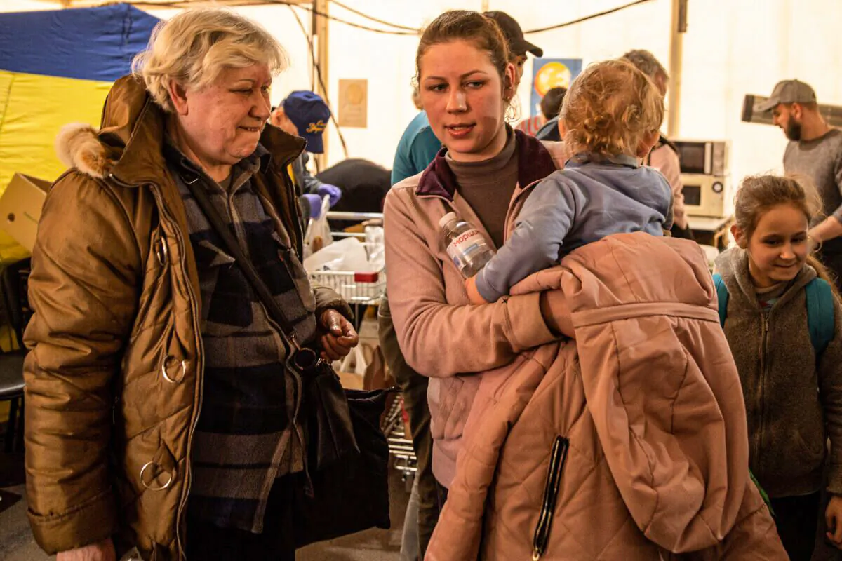 A woman carries her baby in a reception tent after arriving at an evacuation point for people fleeing the Azovstal plant, Mariupol, Melitopol and the surrounding towns under Russian control, in Zaporizhzhia, Ukraine, on May 3, 2022. (Chris McGrath/Getty Images)