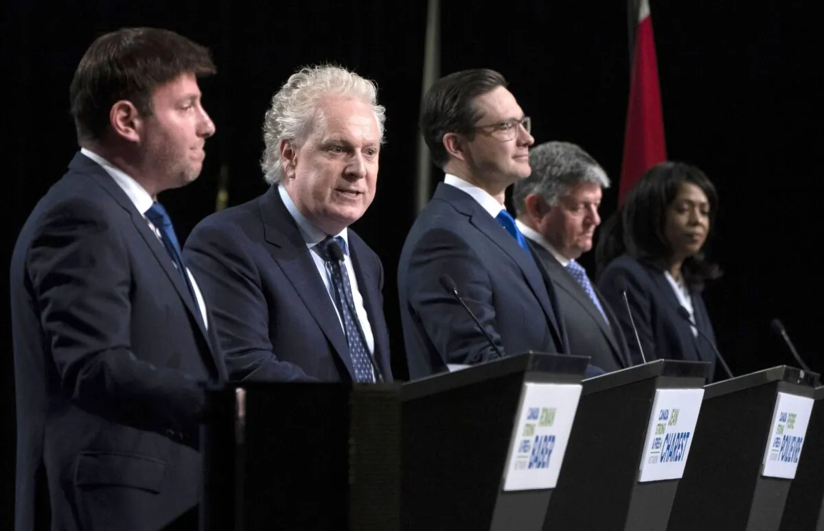 (L-R) Conservative leadership candidates Roman Baber, Pierre Poilievre, Scott Aitchison, and Leslyn Lewis listen as Jean Charest (2nd L) speaks during a debate at the Canada Strong and Free Network conference in Ottawa on May 5, 2022. (The Canadian Press/Adrian Wyld)
