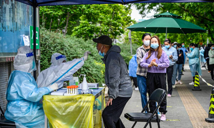 A health worker takes a swab sample from a man to be tested for COVID-19 coronavirus at a makeshift testing site along a street in Beijing on May 7, 2022. (Jade Gao/AFP via Getty Images)