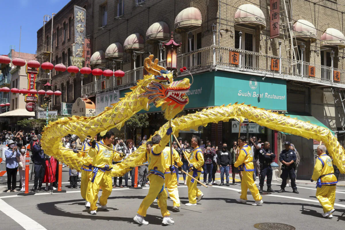 A golden dragon performs for a crowd during the parade commemorating the 30th anniversary of Falun Dafa in San Francisco on May 7, 2022. (Cynthia Cai/The Epoch Times)