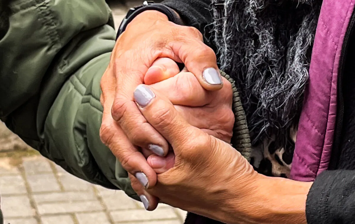 An aid worker and a Ukrainian refugee clasp hands. (Courtesy of Tali Miles)