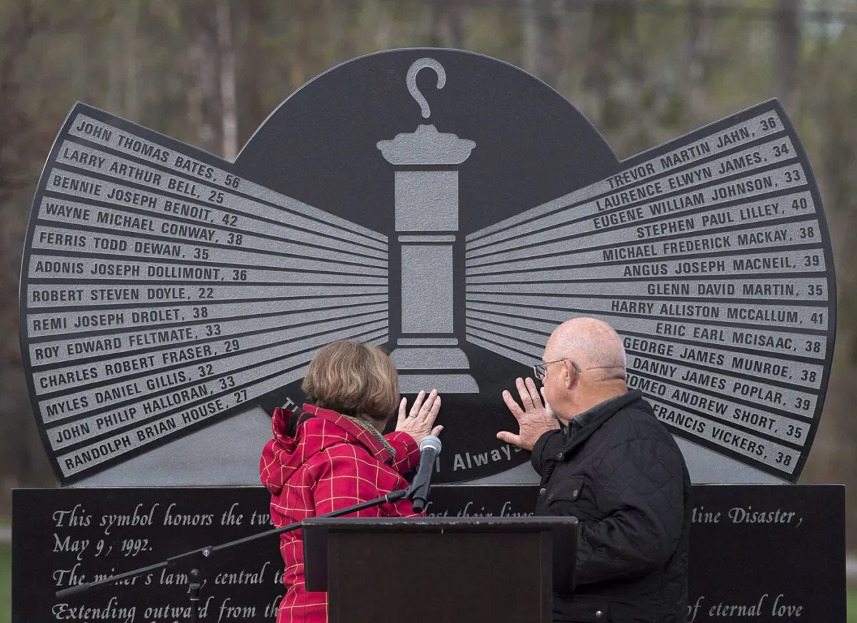 Allen and Debbie Martin touch the monument engraved with the names of the 26 coal miners who perished in the Westray mine disaster, at the Westray Miners Memorial Park in New Glasgow, N.S. on May 9, 2017. (The Canadian Press/Andrew Vaughan)