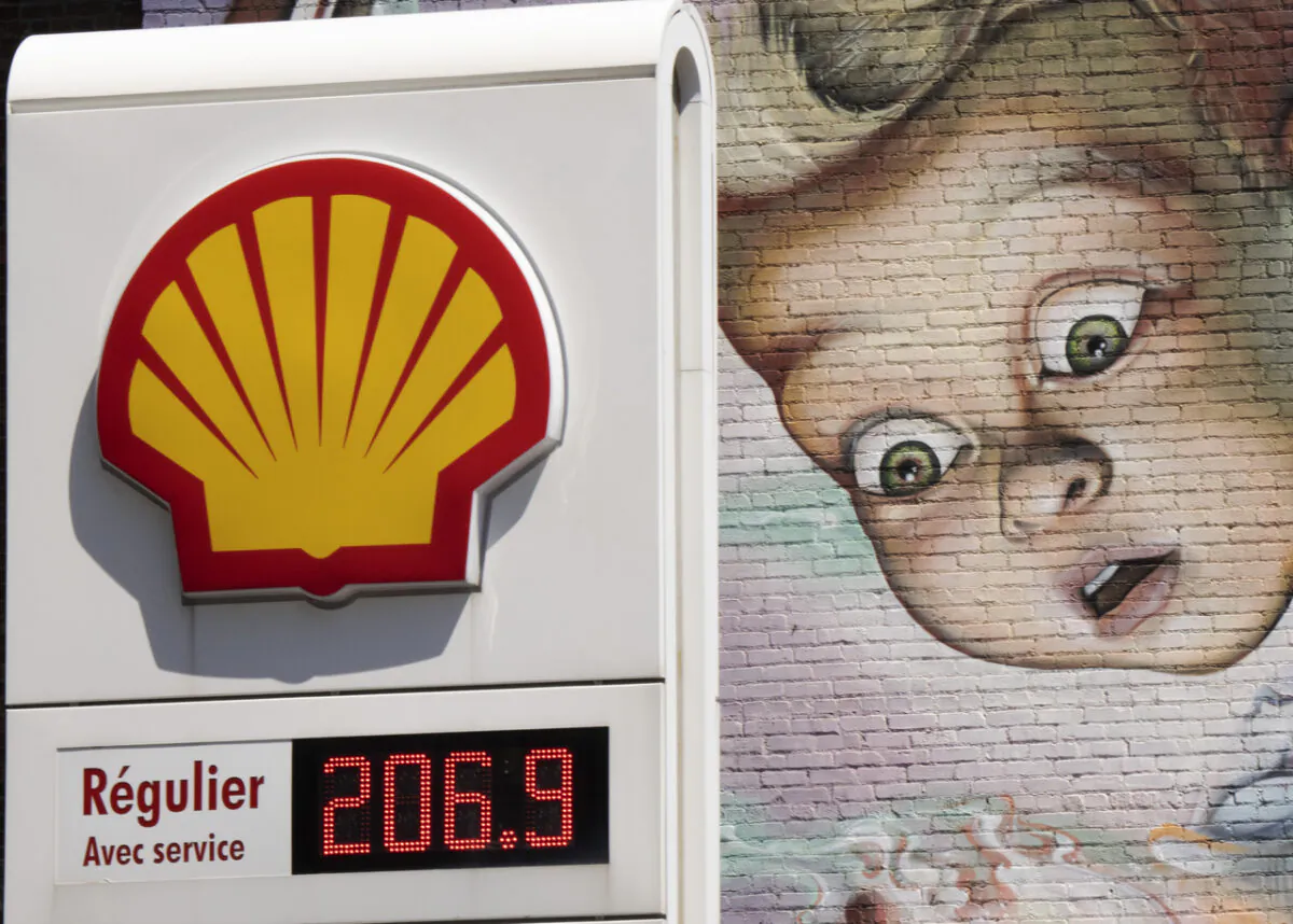 A gas station sign in front of a wall mural, as gas prices surpass $2.00 a litre in Montreal on May 9, 2022. (Ryan Remiorz/The Canadian Press)