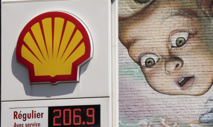 A gas station sign in front of a wall mural, as gas prices surpass $2.00 a litre in Montreal on May 9, 2022. (Ryan Remiorz/The Canadian Press)