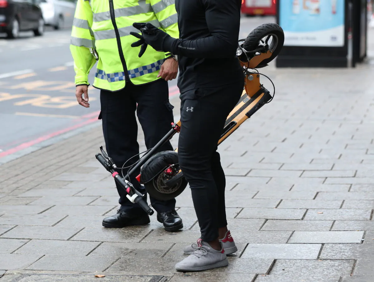 A policeman talks to a man with an e-scooter, in an undated file photo. (Yui Mok/PA)