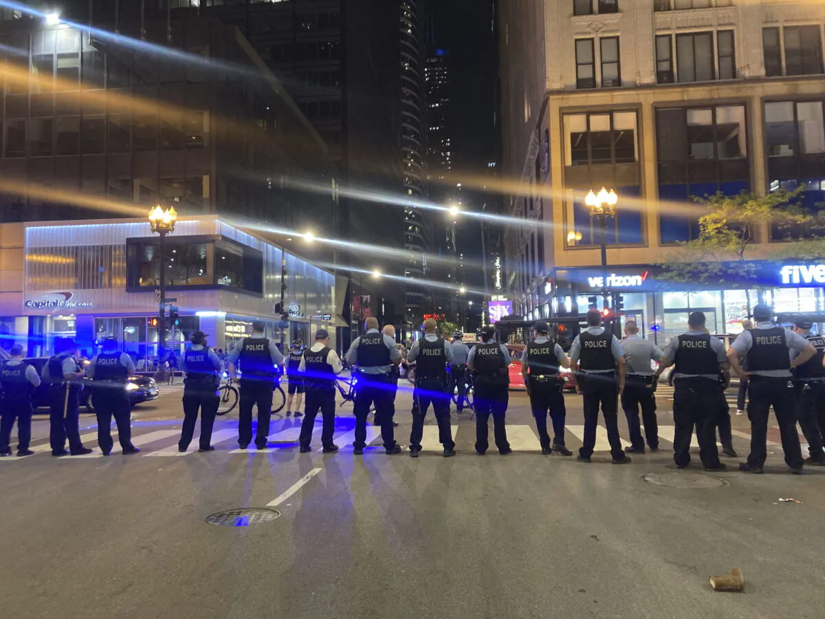 Chicago police block traffic near State and Monroe streets after crowds of young people flooded the Loop after a fatal shooting in Millennial Park in Chicago, on May 14, 2022. (Tina Sfondeles/Chicago Sun-Times via AP)