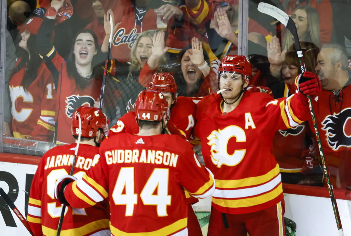 Calgary Flames forward Johnny Gaudreau (13) celebrates his goal with teammates during overtime NHL playoff hockey action against the Dallas Stars in Calgary, Alberta, Canada, on May 15, 2022. (Jeff McIntosh/The Canadian Press via AP)