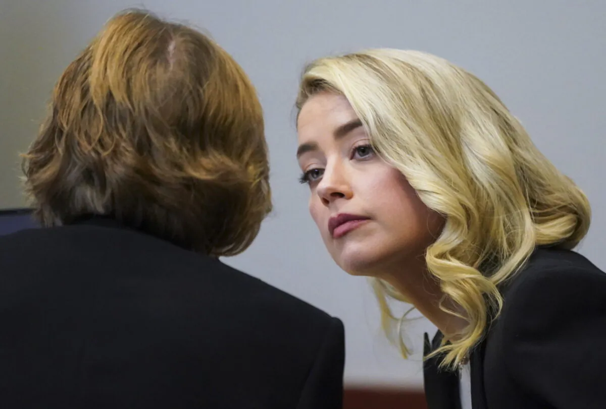 Actress Amber Heard talks with her lawyer Elaine Bredehoft in the courtroom at the Fairfax County Circuit Courthouse in Fairfax, Va., on May 18, 2022. (Kevin Lamarque/Pool Photo via AP)