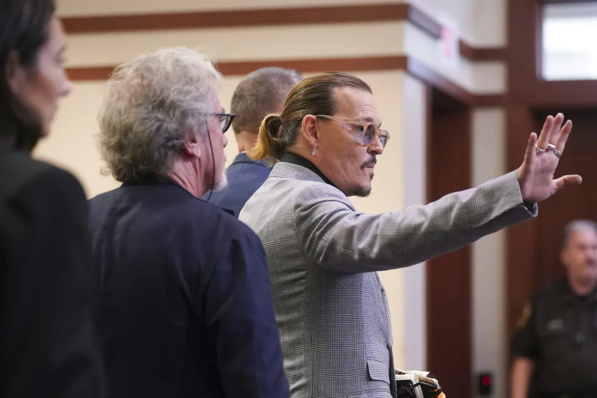 Actor Johnny Depp waves as he leaves the courtroom at the Fairfax County Circuit Courthouse in Fairfax, Va., on May 19, 2022. (Shawn Thew/Pool Photo via AP)