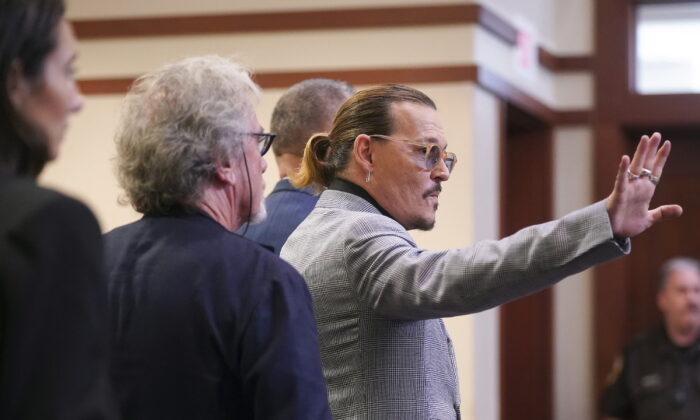 Actor Johnny Depp waves as he leaves the courtroom at the Fairfax County Circuit Courthouse in Fairfax, Va., on May 19, 2022. (Shawn Thew/Pool Photo via AP)