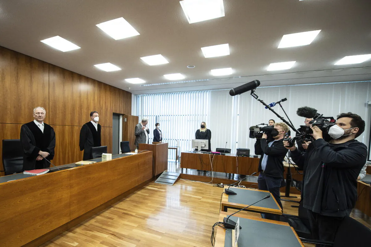 Volker Muetze (L), presiding judge at the Regional Court, stands in the courtroom for the opening in Kassel, Germany, on May 25, 2022. (Swen Pfoertner/dpa via AP)