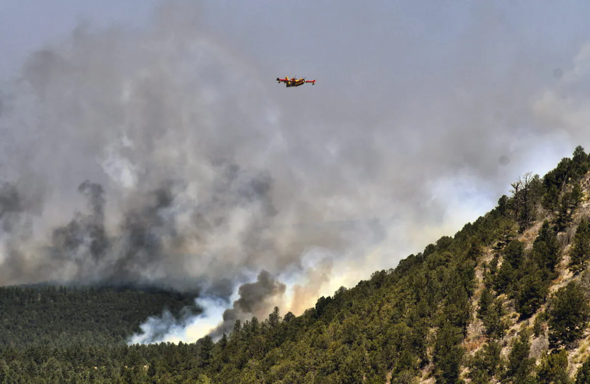 A firefighting plane flies over a plume of smoke near Las Vegas on May 4, 2022. (Thomas Peipert/AP Photo)