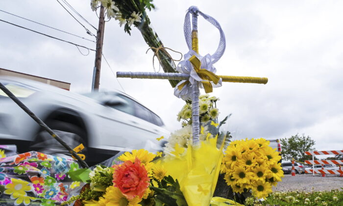 2022 年 3 月 22 日，琳达·弗里基 (Linda Frickey) 的尸体在一天前在新奥尔良的皮尔斯街 (N. Pierce Street) 被劫车拖死后被发现的地方，可以看到一堆鲜花和一个带有光环的十字架。 （Max Becherer/The Times-Picayune/The New Orleans Advocate via AP）