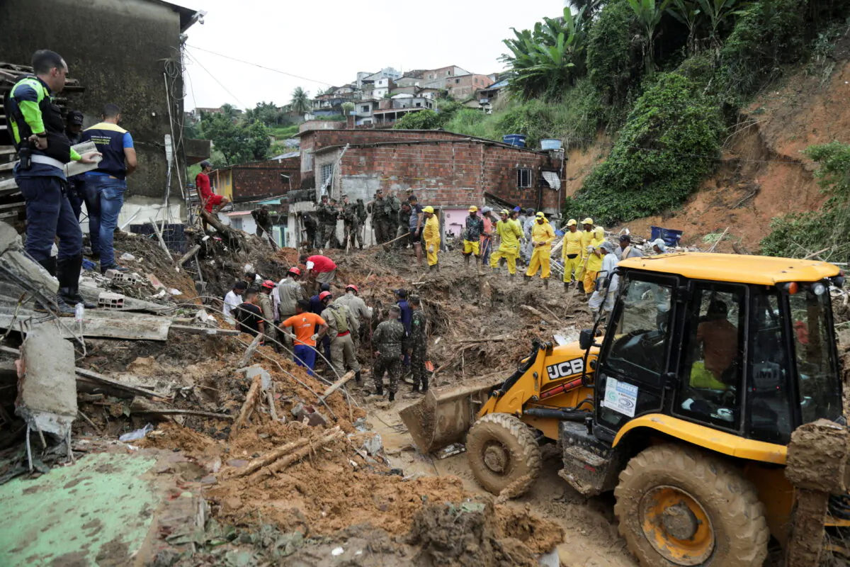 Firefighters, volunteers and army officers work on the site where a house collapsed due to a landslide caused by heavy rains at Jardim Monte Verde, in Ibura neighborhood, in Recife, Brazil, on May 29, 2022. (Diego Nigro/Reuters)