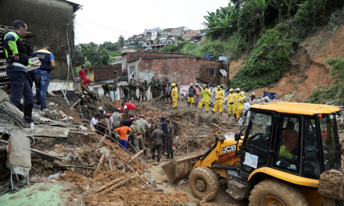 Firefighters, volunteers and army officers work on the site where a house collapsed due to a landslide caused by heavy rains at Jardim Monte Verde, in Ibura neighborhood, in Recife, Brazil, on May 29, 2022. (Diego Nigro/Reuters)
