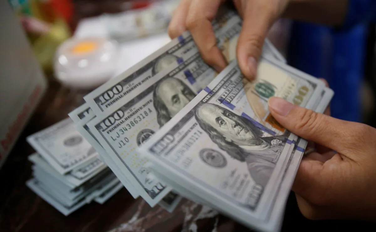 An employee of a bank counts U.S. dollar notes at a branch in Hanoi, Vietnam, on May 16, 2016. (Kham/Reuters)