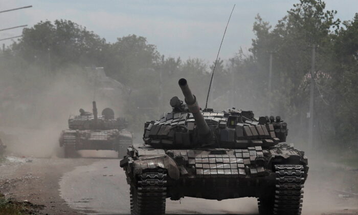 Tanks of pro-Russian troops drive along a street during Ukraine-Russia conflict in the town of Popasna in the Luhansk Region, Ukraine, on May 26, 2022. (Alexander Ermochenko/Reuters)