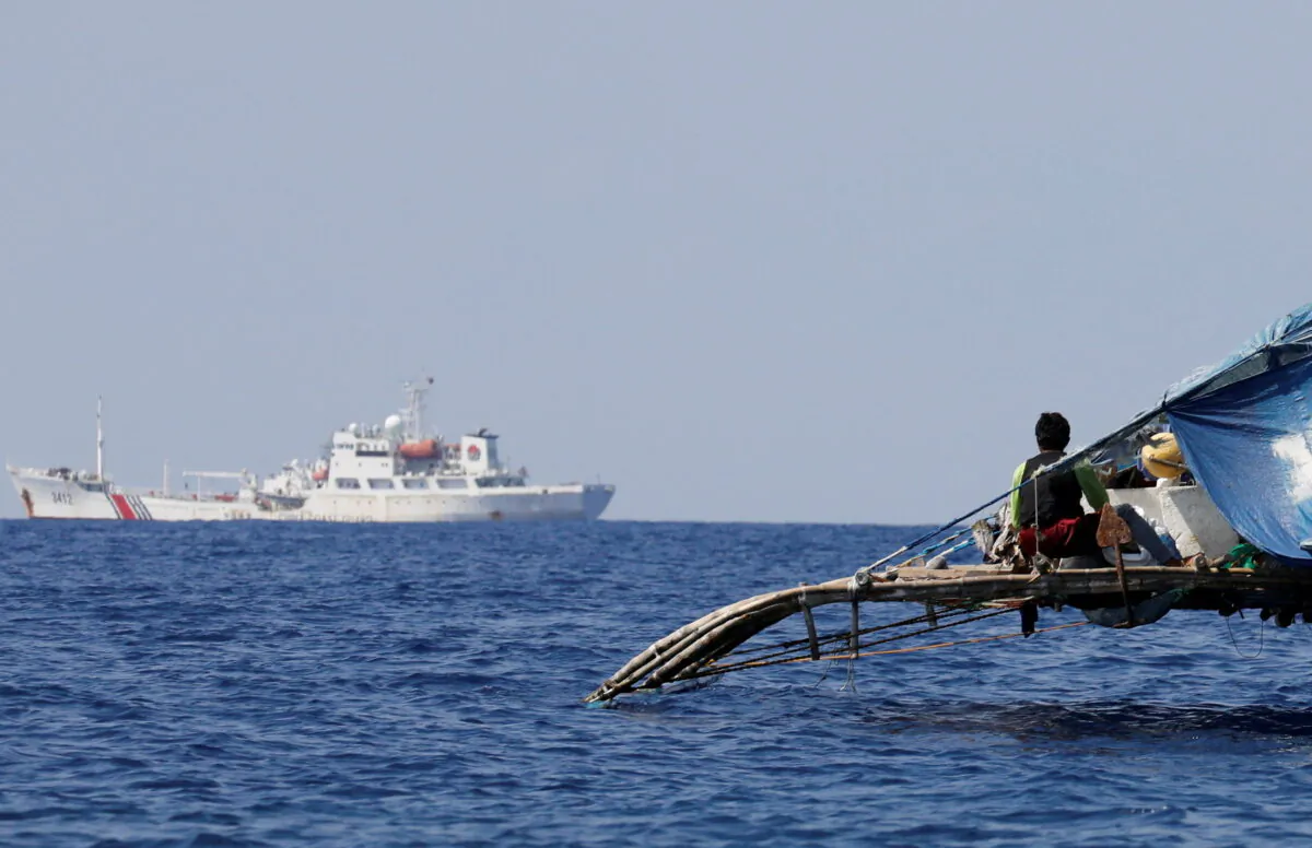 A Philippine fisherman watches a China Coast Guard vessel patrolling the disputed Scarborough Shoal on April 5, 2017. (Erik De Castro/Reuters)