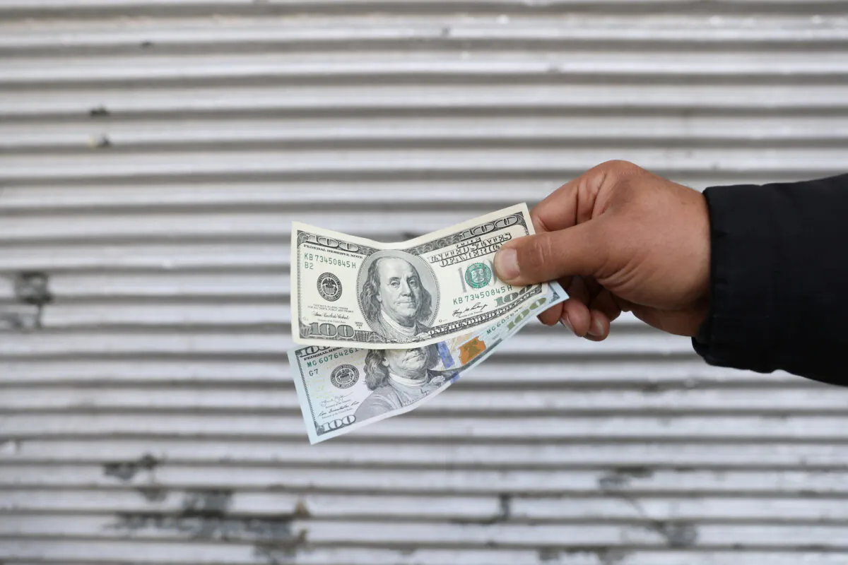 A street-side currency vendor holds U.S. dollars at Ferdowsi Square in Tehran, Iran, on Nov. 14, 2021. (Majid Asgaripour/WANA (West Asia News Agency) via Reuters)