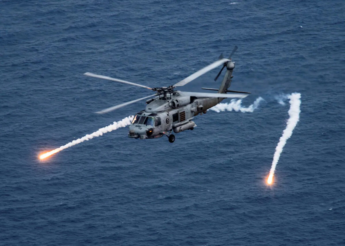 A U.S. Navy MH-60R Sea Hawk helicopter chaff flares during a training exercise near the aircraft carrier USS Carl Vinson in the Philippine Sea on April 24, 2017. (US Navy/Mass Communication Specialist 2nd Class Sean M. Castellano/Reuters)