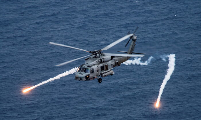 A U.S. Navy MH-60R Sea Hawk helicopter chaff flares during a training exercise near the aircraft carrier USS Carl Vinson in the Philippine Sea on April 24, 2017. (US Navy/Mass Communication Specialist 2nd Class Sean M. Castellano/Reuters)