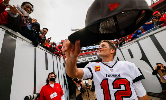 Tampa Bay Buccaneers quarterback Tom Brady (12) hands his hat to a fan after beating the Philadelphia Eagles 31–15 in a NFC Wild Card playoff football game at Raymond James Stadium in Tampa, Fla.. ( Nathan Ray Seebeck/USA Today Sports )    