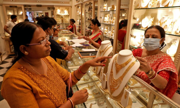 A customer checks a gold necklace before buying it at a jewellery showroom on the occasion of Akshaya Tritiya, a major gold buying festival, in Kolkata, India, on May 3, 2022. (Rupak De Chowdhuri/Reuters)