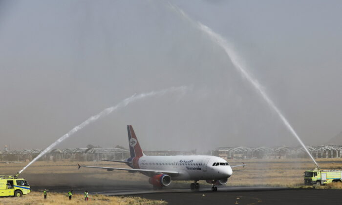 A Yemen Airways plane is greeted with water canon salute at Sanaa Airport as the first commercial flight in around six years, in Sanaa, Yemen on May 16, 2022. (Khaled Abdullah/Reuters)
