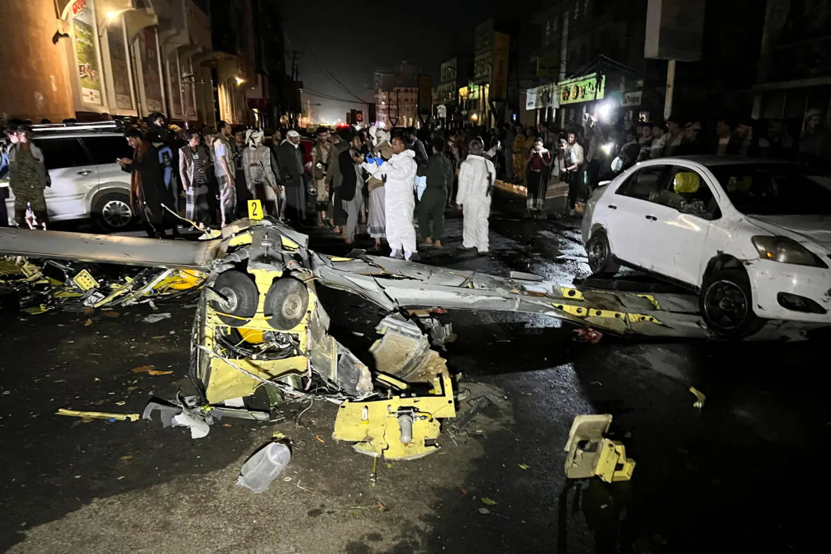 Residents and security personnel gather around the wreckage of a drone aircraft on a street in Sanaa, Yemen on May 23, 2022. (Adel al-Khadher/Reuters)