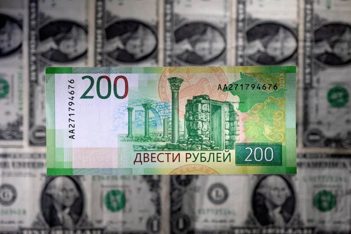 A Russian ruble banknote is seen placed on U.S. dollar banknotes in this illustration taken on March 1, 2022. (Dado Ruvic/Illustration/Reuters)
