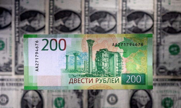 A Russian ruble banknote is seen placed on U.S. dollar bills in this illustration image taken on March 1, 2022. (Dado Ruvic/Illustration/Reuters)