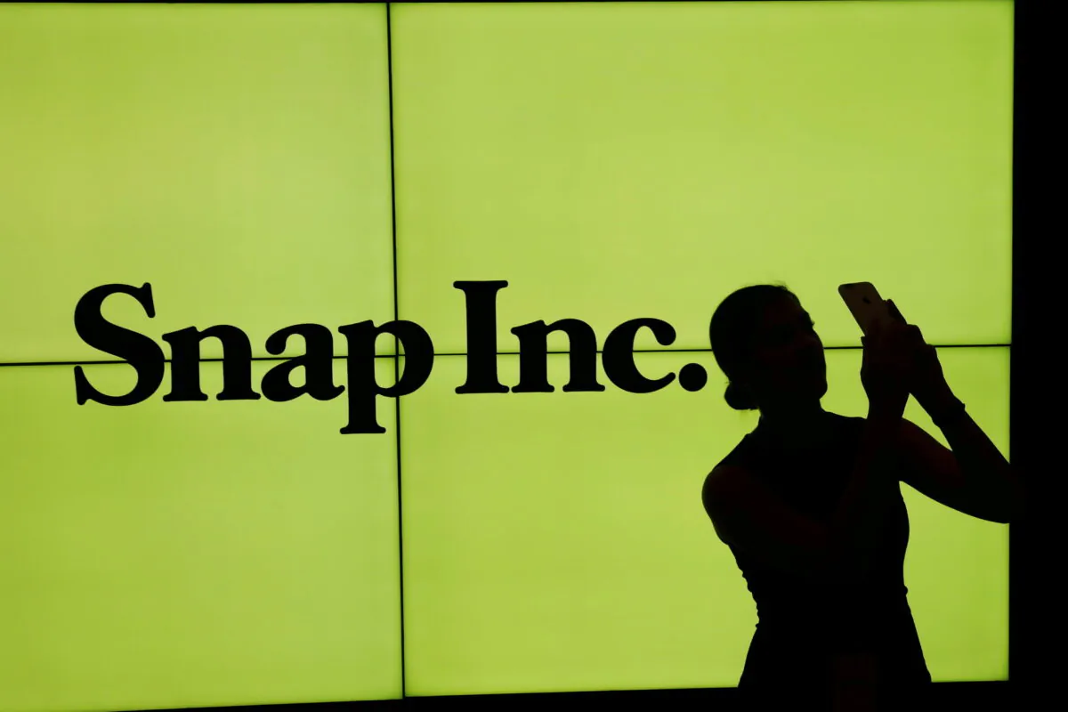 A woman stands in front of the logo of Snap Inc. on the floor of the New York Stock Exchange (NYSE) in New York City on March 2, 2017. (Lucas Jackson/Reuters)