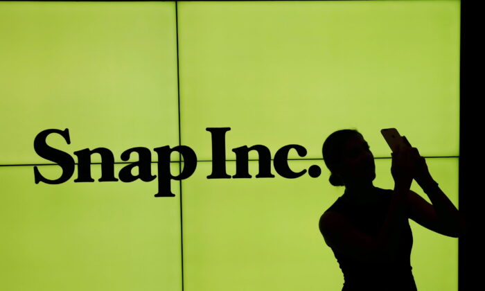 A woman stands in front of the logo of Snap Inc. on the floor of the New York Stock Exchange (NYSE) in New York City on March 2, 2017. (Lucas Jackson/Reuters)