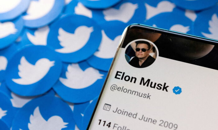 Elon Musk's Twitter profile on a smartphone placed on printed Twitter logos, on April 28, 2022. (Dado Ruvic/Reuters)