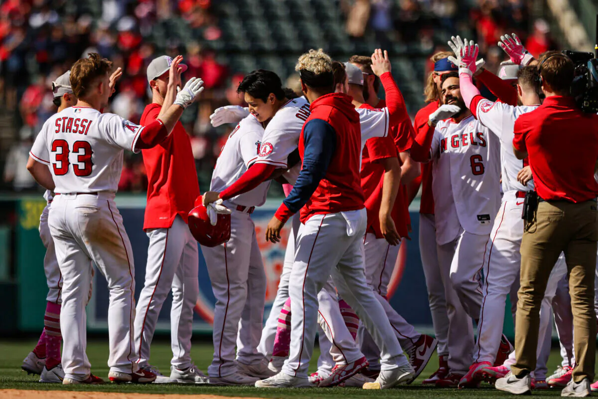 The Los Angeles Angels celebrate a 5-4 win against the Washington Nationals. Shohei Ohtani centered holding helmet, and Anthony Renden #) at Angel Stadium of Anaheim, in Anaheim, on May 8, 2022. (Katharine Lotze/Getty Images)